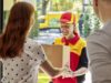 Parcel delivery woman handing over package to Women in doorway