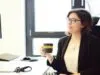 Women in office talking with coffee mug in hand