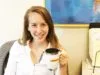 women in office smiling at camera with coffee mug in hand