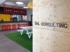Close-up of lettering "DHL Consulting" on wooden wall in office